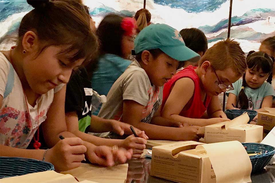Children writing notes to interact with Let Go